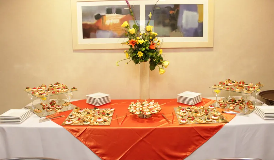 Mesa de catering para evento empresarial con bocadillos